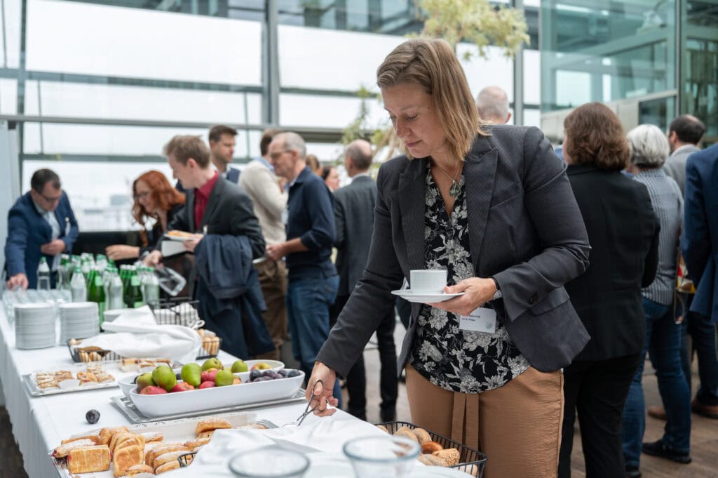 Vielfalt an professionellen Richterinnen und Richtern bei einer Konferenz oder Veranstaltung in einem modernen, lichtdurchfluteten Raum.