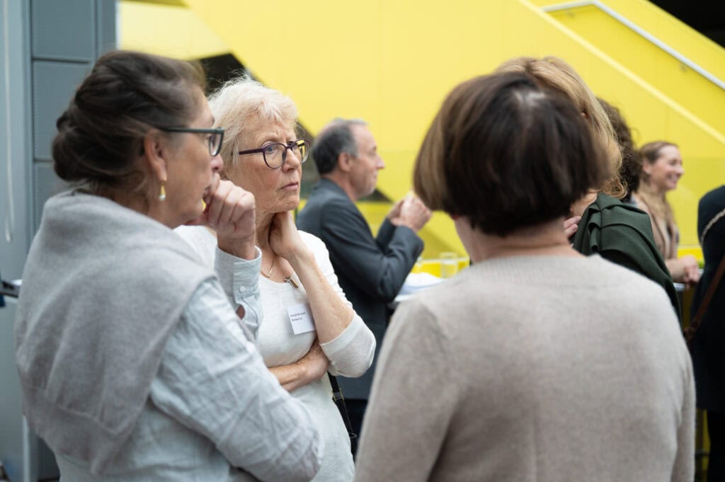 Menschen bei einer Veranstaltung der Richtervereinigung in Österreich, Fokus auf ältere Frauen im Gespräch, professionelle Atmosphäre, networking, Rechtsanwälte, Juristen, Konferenz.