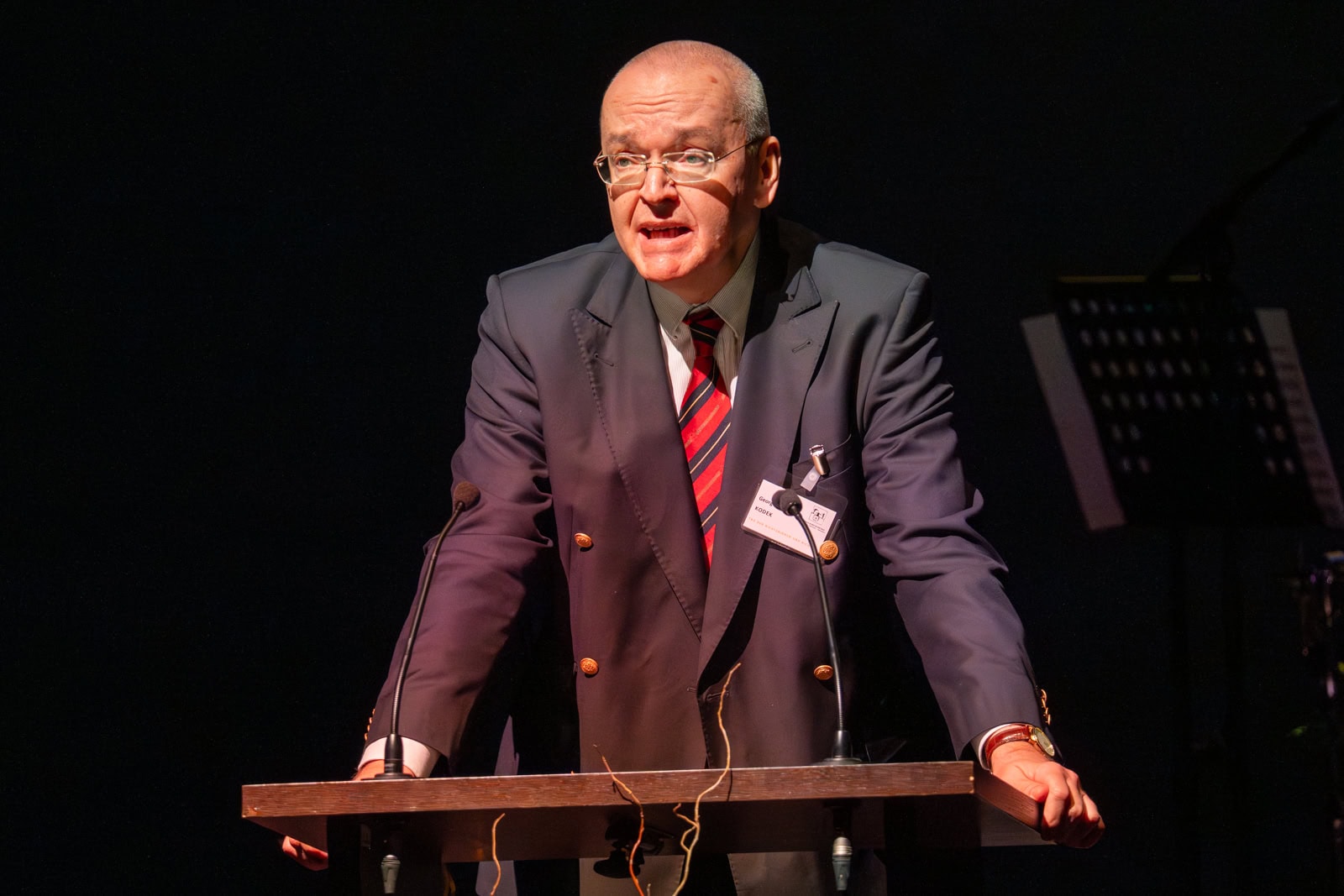 Richter bei Veranstaltung, moderiert einen Vortrag oder eine Diskussion, professionelle Veranstaltung, Fokus auf Rechtssicherheit, Gericht, Magistrat, rechtliche Expertise.