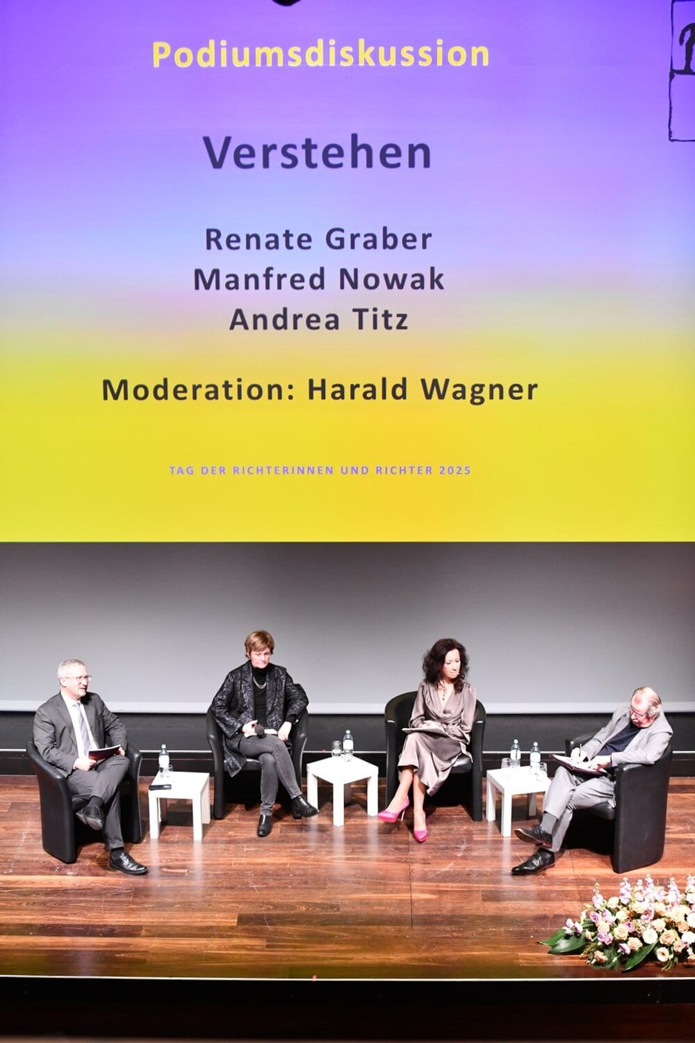Professionelle Richter und Juristen bei kritischer Diskussion, moderiert von Harald Wagner, im Rahmen von Tag der Richterinnen und Richter 2025 in Österreich.