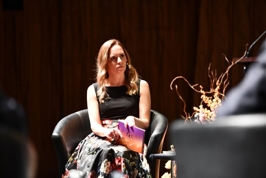 Alt-Text: Frauen bei einer Veranstaltung des Richtervereins in einem modernen Saal, im Gespräch, mit Blumen und moderner Einrichtung im Hintergrund.