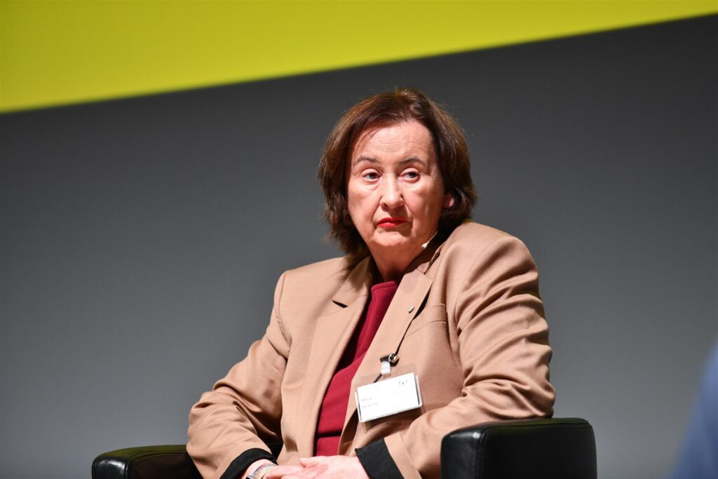 Hochwertiges Bild einer Richterin während einer Diskussion bei einer Fachveranstaltung. Professionelle Richtervereinigung in Österreich, Fokus auf Rechtssymbole und juristische Expertise.